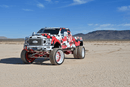 Ford F450 Camouflage-patterned truck in a desert landscape with mountains in the background With Premium Predator New Mutant X-MT on it